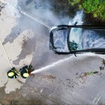 Emergency responders attending a car accident on a road, aerial view