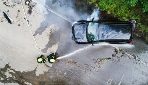 Emergency responders attending a car accident on a road, aerial view